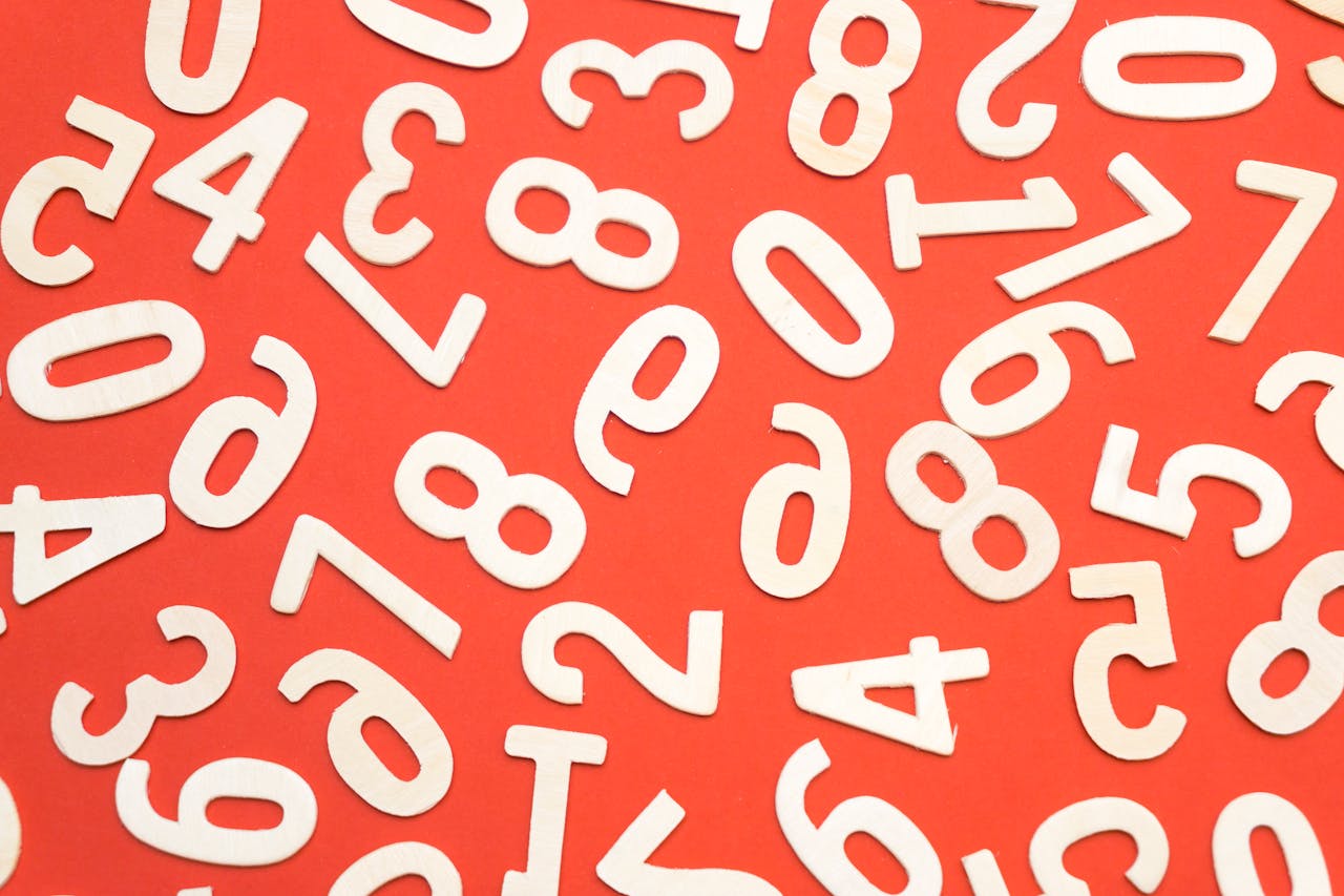 Artistic scattered white numbers on a bright red background, geometric and abstract.